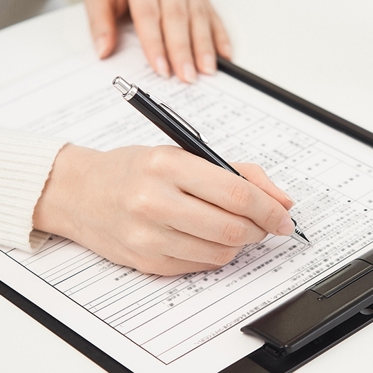 歯列矯正の契約書類に記入するイメージ