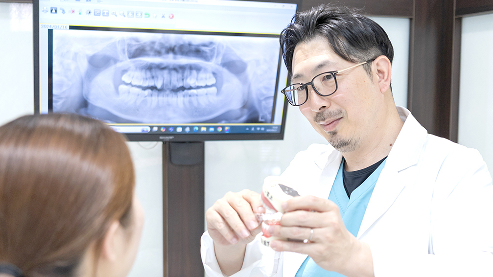 亀山で歯並びの矯正相談を行う院長と、説明を受ける矯正歯科患者